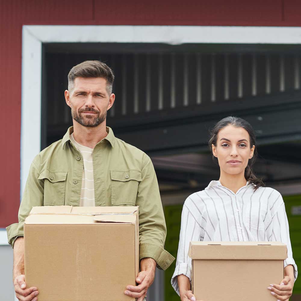 Par holder esker foran et minilager